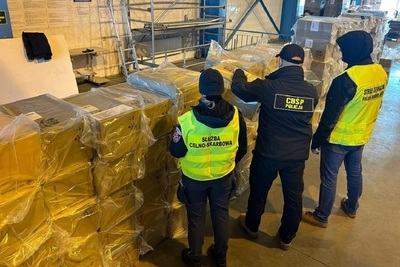Funkcjonariusze SG, Służby Celno-Skarbowej i CBŚP stoją przy paczkach z nielegalnymi papierosami Funkcjonariusze SG, Służby Celno-Skarbowej i CBŚP stoją przy paczkach z nielegalnymi papierosami