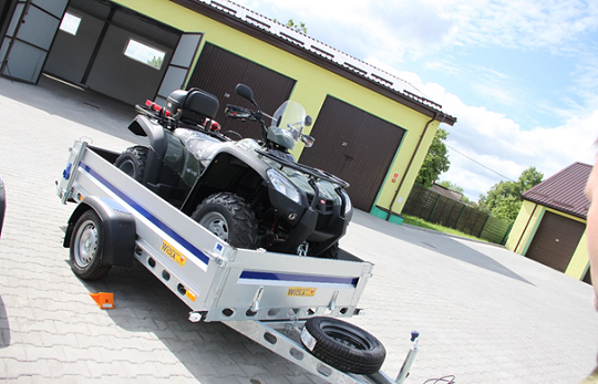 pojazd klasy ATV z napędem 4x4 na przyczepie dostosowanej do transportu