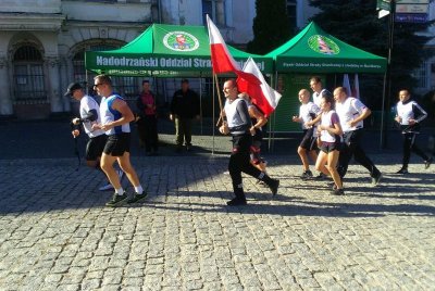 Złoty Stok. Na rynek wbiega ostatnia zmiana funkcjonariuszy Śląskiego OSG prowadzona przez Zastępcę Komendanta OSG płk. SG Marka Kocha. (Nadodrzański OSG, 30.09.2018 g. 15.00)