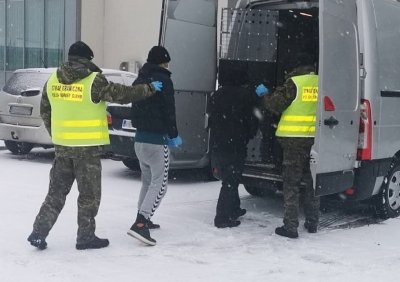 Zatrzymani imigranci wsiadają do pojazdu służbowego SG, 