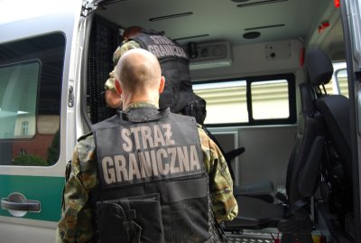 Zatrzymany za produkcję i posiadanie narkotyków pod nadzorem funkcjonariusza wsiada do pojazdu służbowego SG. Zatrzymany za produkcję i posiadanie narkotyków pod nadzorem funkcjonariusza wsiada do pojazdu służbowego SG.