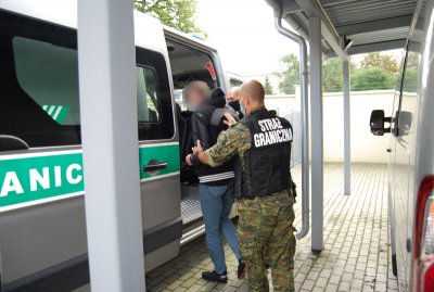 Zatrzymany za produkcję i posiadanie narkotyków pod nadzorem funkcjonariusza wsiada do pojazdu służbowego SG. Zatrzymany za produkcję i posiadanie narkotyków pod nadzorem funkcjonariusza wsiada do pojazdu służbowego SG.