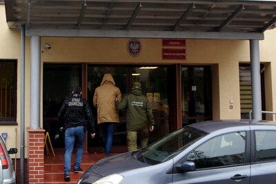 Zatrzymany wprowadzany przez funkcjonariuszy SG do siedziby prokuratury 