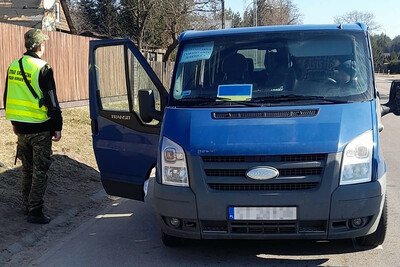 Funkcjonariusz Straży Granicznej obok kontrolowanego pojazdu 