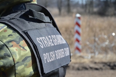 Funkcjonariusz Straży Granicznej na tle granicy RP 