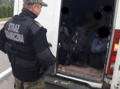 Funkcjonariusz SG w trakcie kontroli przestrzeni bagażowej busa 