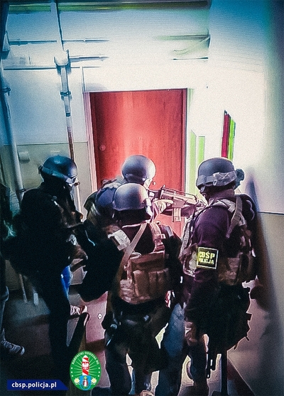 uzbrojeni funkcjonariusze wchodzący do mieszkania 