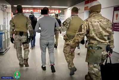 funkcjonariusze SG prowadzący osobę zatrzymaną na lotnisku 