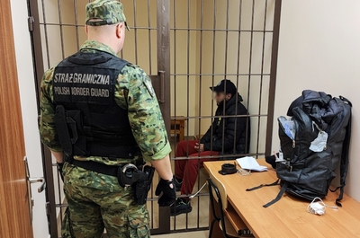 Funkcjonariusz SG z jednym z zatrzymanych cudzoziemców 