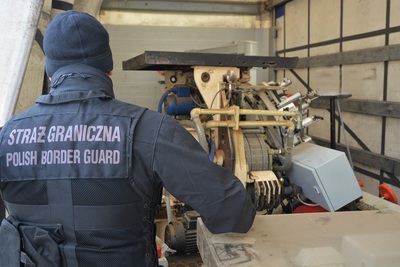 Funkcjonariusz SG zabezpiecza linię produkcyjną 