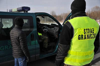 Funkcjonariusz SG zatrzymuje migrantów 