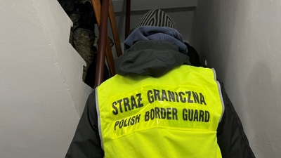 Funkcjonariusze SG wchodzą do lokalu, gdzie zatrzymano organizatora nielegalnego przekraczania granicy 