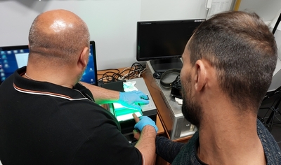 Funkcjonariusz SG pobiera odciski palców cudzoziemca 