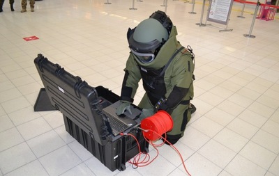 Funkcjonariusz SG w trakcie przygotowania do sprawdzenia pozostawionego bez opieki bagażu robotem pirotechnicznym 
