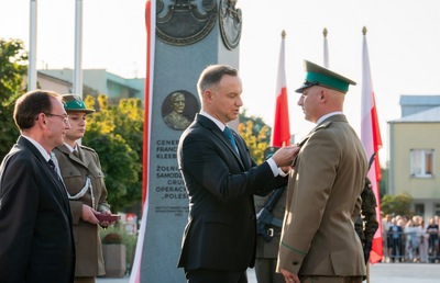 Prezydent RP, w asyście Ministra SWiA, dekoruje funkcjonariusza SG Krzyżem Zasługi za Dzielność 