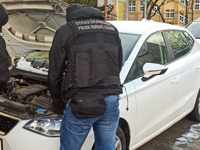 Funkcjonariusz SG zabezpiecza auto 