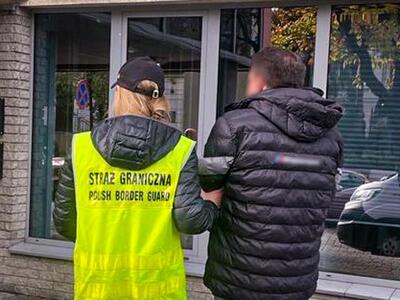 Funkcjonariusz SG zatrzymuje jednego z podejrzanych 