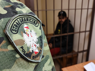 funkcjonariusz SG, osoba zatrzymana w tle 