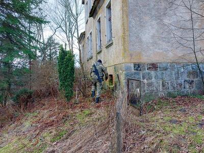 Funkcjonariusz SG przy oknie piwnicy domu 