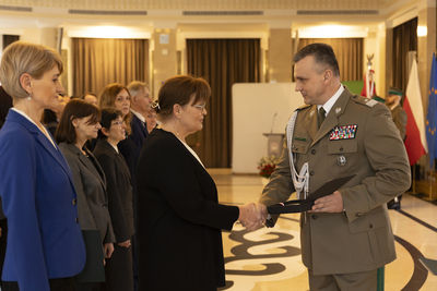 Komendant Główny SG wręcza pracownicy KGSG okolicznościowy list z okazji Dnia Służby Cywilnej 