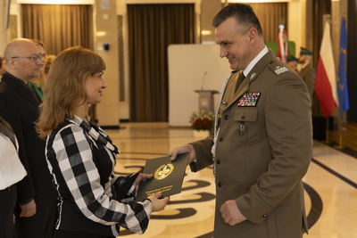 Komendant Główny SG wręcza pracownicy KGSG okolicznościowy list z okazji Dnia Służby Cywilnej 