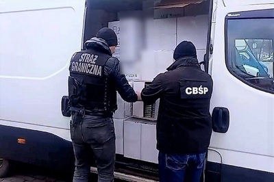 Funkcjonariusz SG i CBŚ podczas przeglądania zawartości pojazdu 