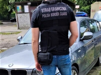 Funkcjonariusz Straży Granicznej stoi przy pojeździe Funkcjonariusz Straży Granicznej stoi przy pojeździe