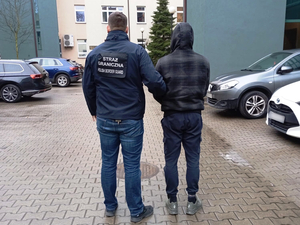 Funkcjonariusz SG prowadzi Białorusina zatrzymanego za kierowanie grupą przestępczą Funkcjonariusz SG prowadzi Białorusina zatrzymanego za kierowanie grupą przestępczą