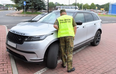 Funkcjonariusz SG stoi przy odzyskanym Range Roverem Funkcjonariusz SG stoi przy odzyskanym Range Roverem