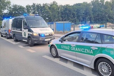 Pojazdy służbowe SG i ITD stoją przodem do siebie Pojazdy służbowe SG i ITD stoją przodem do siebie