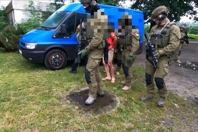 Funkcjonariusze Straży Granicznej przy pojeździe i dwie osoby zatrzymane Funkcjonariusze Straży Granicznej przy pojeździe i dwie osoby zatrzymane