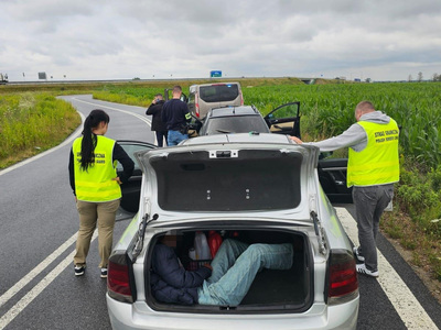 Czterej funkcjonariusze Straży Granicznej, dwa pojazdy i osoba w przestrzeni ładunkowej pojazdu Czterej funkcjonariusze Straży Granicznej, dwa pojazdy i osoba w przestrzeni ładunkowej pojazdu