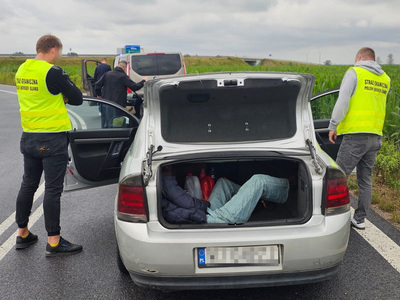 Czterej funkcjonariusze Straży Granicznej, dwa pojazdy i osoba w przestrzeni ładunkowej pojazdu Czterej funkcjonariusze Straży Granicznej, dwa pojazdy i osoba w przestrzeni ładunkowej pojazdu