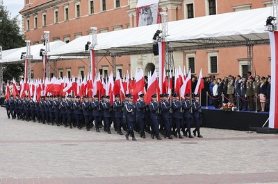 Funkcjonariusze Policji maszerują i niosą biało-czerwone flagi Funkcjonariusze Policji maszerują i niosą biało-czerwone flagi