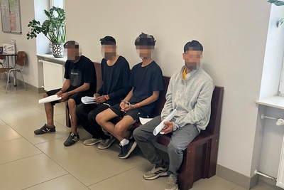 Czterech zatrzymanych cudzoziemców siedzi na ławce Czterech zatrzymanych cudzoziemców siedzi na ławce
