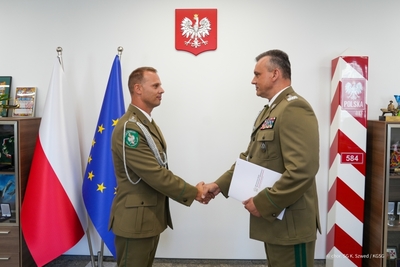 Komendant Główny Straży Granicznej wraz z Komendantem Warmińsko-Mazurskiego Oddziału Straży Granicznej uściskają sobie dłonie Komendant Główny Straży Granicznej wraz z Komendantem Warmińsko-Mazurskiego Oddziału Straży Granicznej uściskają sobie dłonie