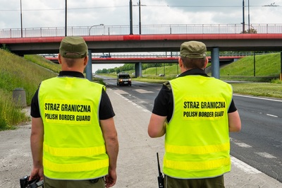 Dwóch funkcjonariuszy Straży Granicznej podczas kontroli ruchu drogowego Dwóch funkcjonariuszy Straży Granicznej podczas kontroli ruchu drogowego