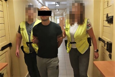 Funkcjonariuszka i funkcjonariusz Straży Granicznej prowadzą zatrzymanego Funkcjonariuszka i funkcjonariusz Straży Granicznej prowadzą zatrzymanego