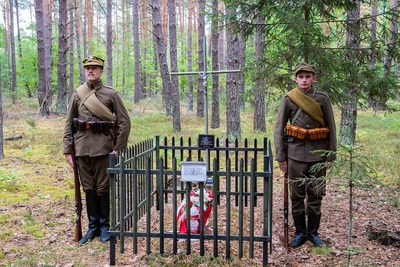 Dwie osoby w mundurach historycznych przy grobie poległego żołnierza Korpusu Ochrony Pogranicza. Dwie osoby w mundurach historycznych przy grobie poległego żołnierza Korpusu Ochrony Pogranicza.