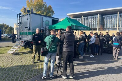 Funkcjonariusz Straży Granicznej, media, młodzież przy stoisku Straży Granicznej Funkcjonariusz Straży Granicznej, media, młodzież przy stoisku Straży Granicznej
