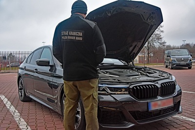 unkcjonariusz Straży Granicznej podczas wykonywania czynności służbowych przy skradzionym BMW. Funkcjonariusz Straży Granicznej podczas wykonywania czynności służbowych przy skradzionym BMW.