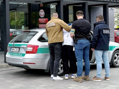 Funkcjonariusze SG i Policji z zatrzymanym mężczyzną. Funkcjonariusze SG i Policji z zatrzymanym mężczyzną.