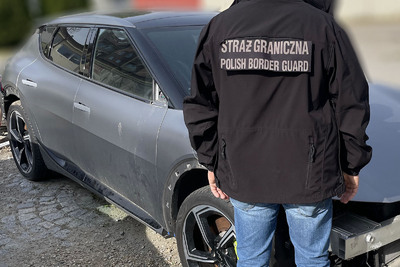 Funkcjonariusz Straży Granicznej stoi przy zatrzymanym pojeździe Funkcjonariusz Straży Granicznej stoi przy zatrzymanym pojeździe