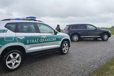 Pojazd służbowy SG za nim stoi zatrzymany samochód Pojazd służbowy SG za nim stoi zatrzymany samochód