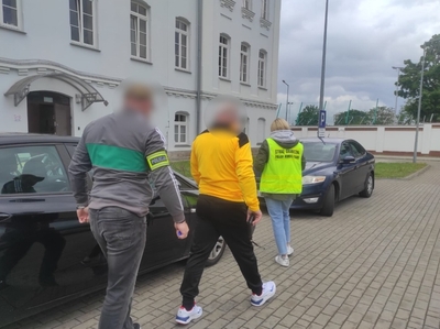 Zatrzymany cudzoziemiec z funkcjonariuszami Straży Granicznej i Policji 