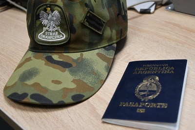 Czapka służbowa funkcjonariusza Straży Granicznej oraz paszport Czapka służbowa funkcjonariusza Straży Granicznej oraz paszport