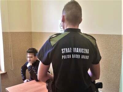 Funkcjonariusz Straży Granicznej z zatrzymanym mężczyzną. Funkcjonariusz Straży Granicznej z zatrzymanym mężczyzną.