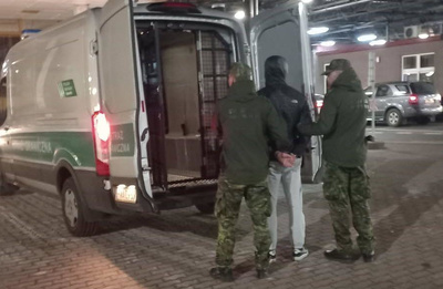 Funkcjonariusze Straży Granicznej z zatrzymanym cudzoziemcem. Funkcjonariusze Straży Granicznej z zatrzymanym cudzoziemcem.