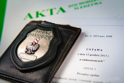 Znak identyfikacyjny Straży Granicznej leży na Ustawie o cudzoziemcach Znak identyfikacyjny Straży Granicznej leży na Ustawie o cudzoziemcach