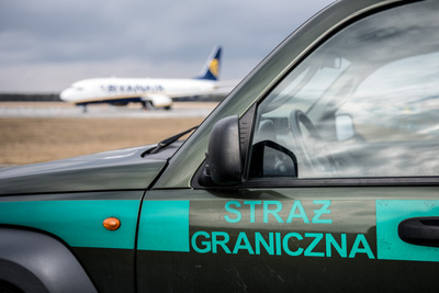 Pojazd służbowy Straży Granicznej w tle samolot Pojazd służbowy Straży Granicznej w tle samolot